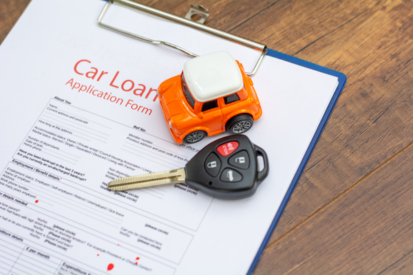 car key laying on car loan paperwork