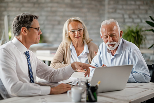 Agent with older couple discussing tips for maximizing insurance coverage