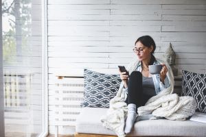 Woman sitting on couch drinking coffee